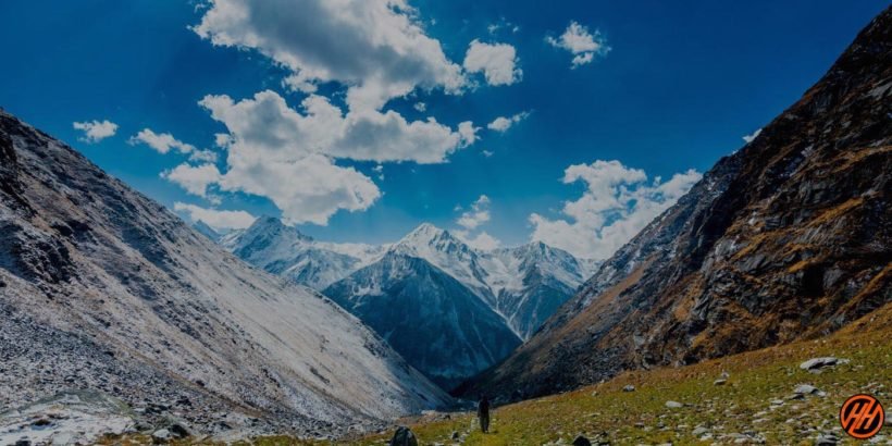 Manida Tall – Serene high-altitude lake surrounded by mountains and lush greenery.